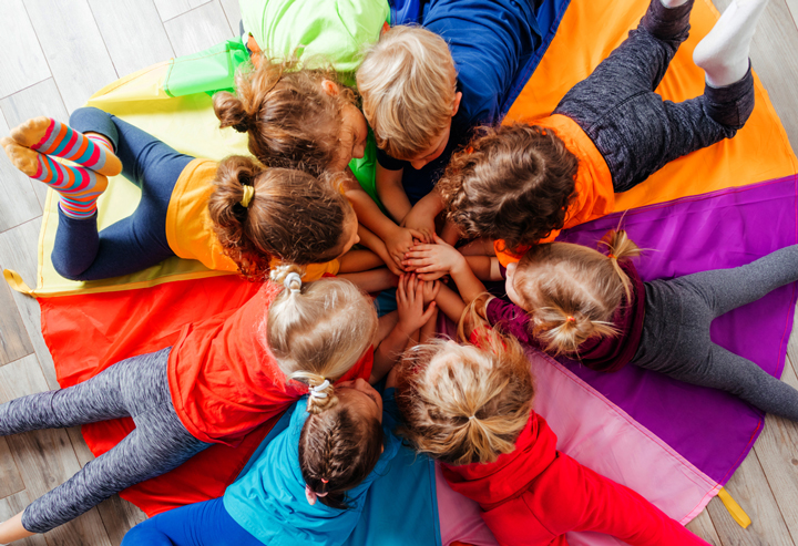 children lying in round on a colorful carpet