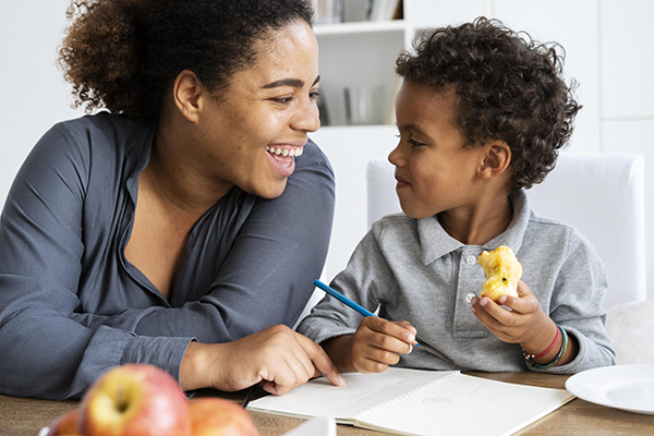 Teacher guiding child during classroom snack routine